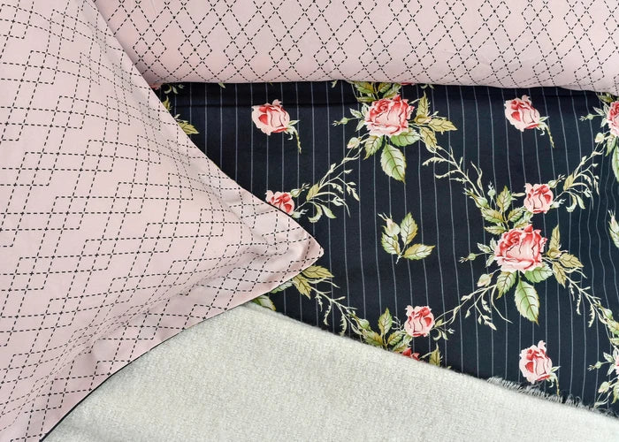 Quilt cover close-up: mauve geometric grid reverse and black floral rose stripe front