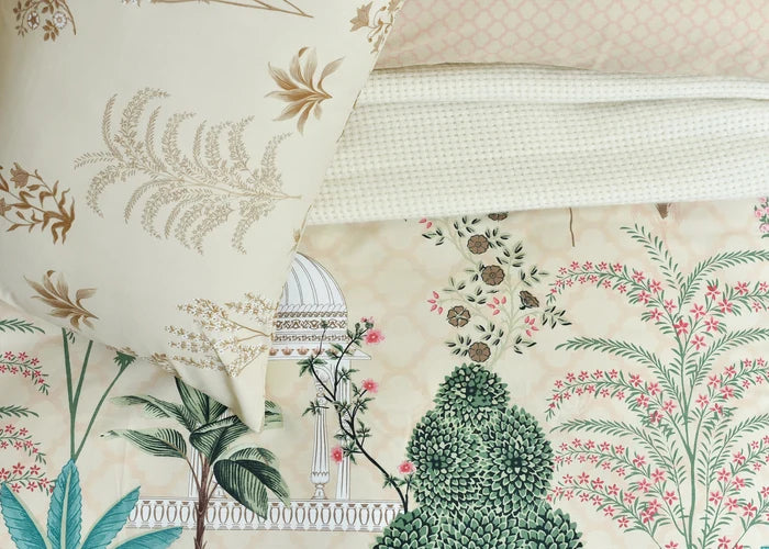 Cotton quilt cover fabric close-up with beige botanical scene, teals and pink flowers