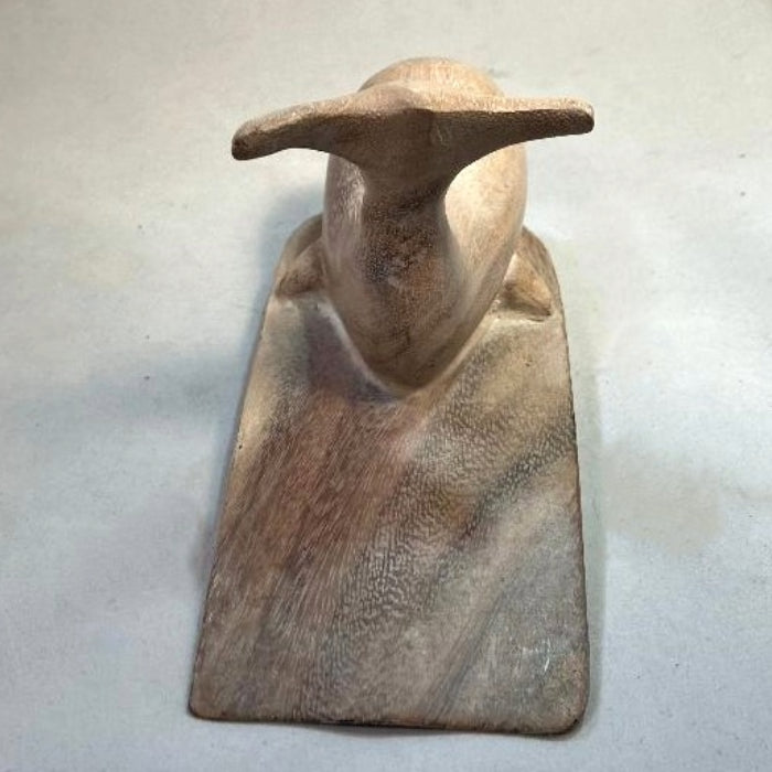 Carved wooden doorstop in the shape of a whale, with a platform under it.