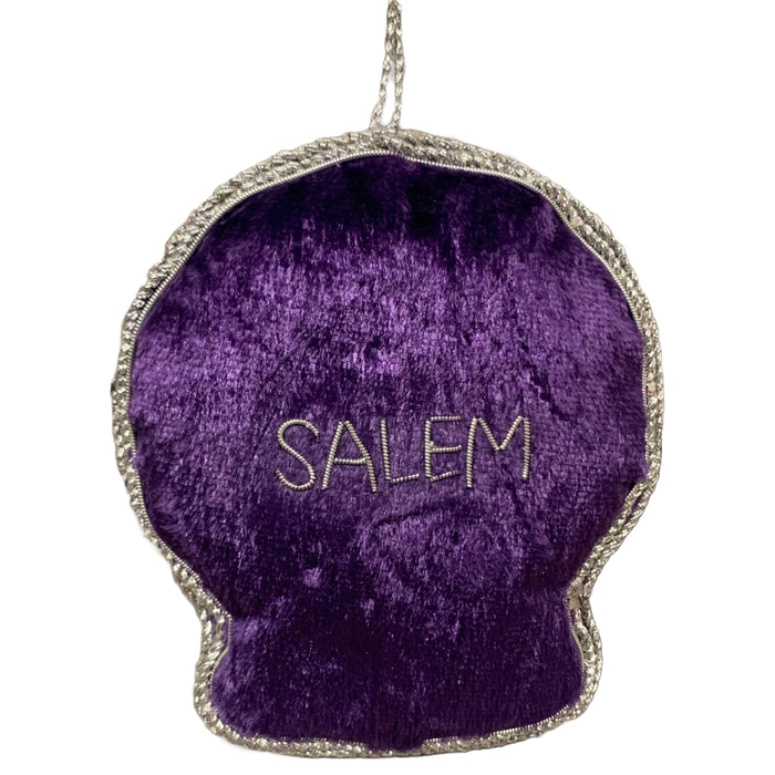A purple velvet crystal ball ornament with silver metallic applique, featuring an eye and stars design, and the word 'Salem' on the reverse.