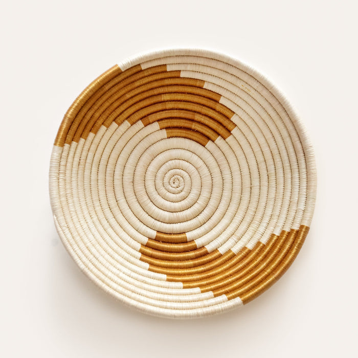 Woven basket with concentric circle pattern on a white background