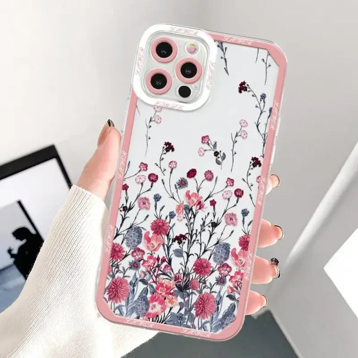 a woman holding a pink phone case with flowers on it