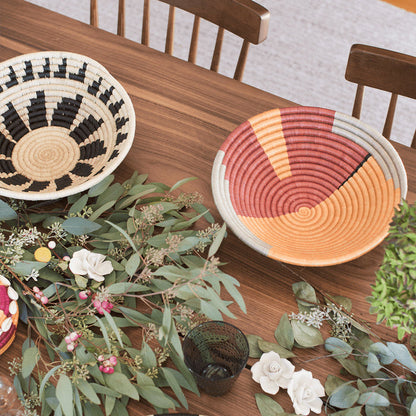 Decorative table setting with woven baskets and floral arrangements on a wooden table.