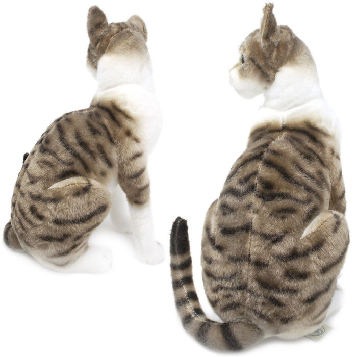 A plush toy resembling an American Shorthair cat with a mackerel tabby coat, featuring a realistic design with stripes, seated upright, with a focus on its face and detailed features.