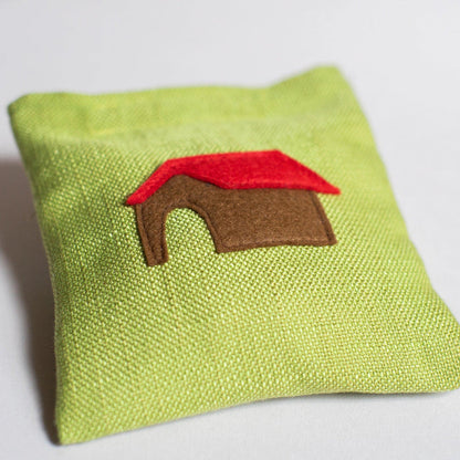Green fabric pouch with a red and brown house design on a white background