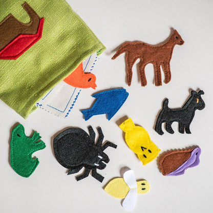 Colorful felt animal shapes on a white surface with a green fabric item.