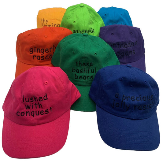 A collection of colorful baseball caps with embroidered text and a white whale on the back.