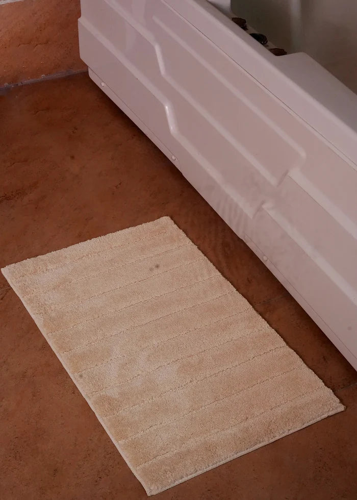 Brown bath mat rug with textured surface and stitched border