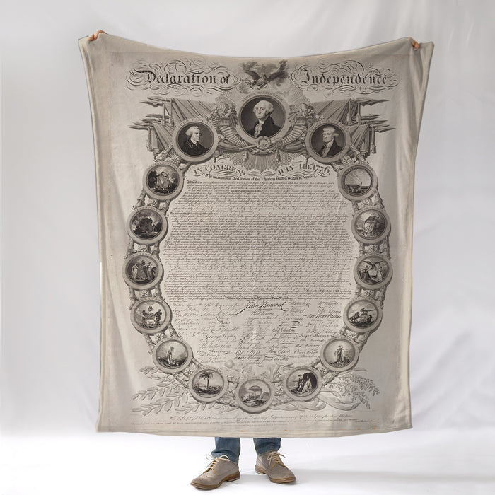 Person holding a blanket with an image of the Declaration of Independence printed on it.