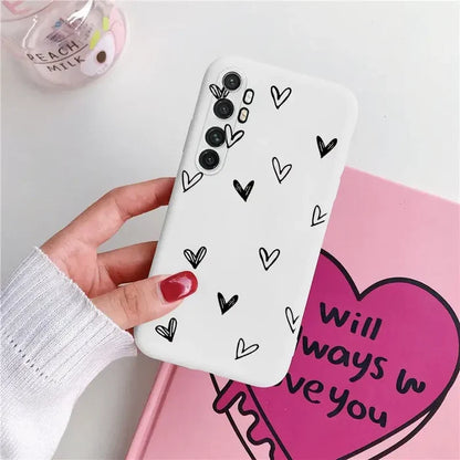 a woman holding a phone case with hearts on it