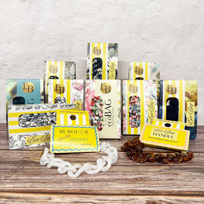 Collection of eco-friendly product packaging on a wooden surface with a light gray background
