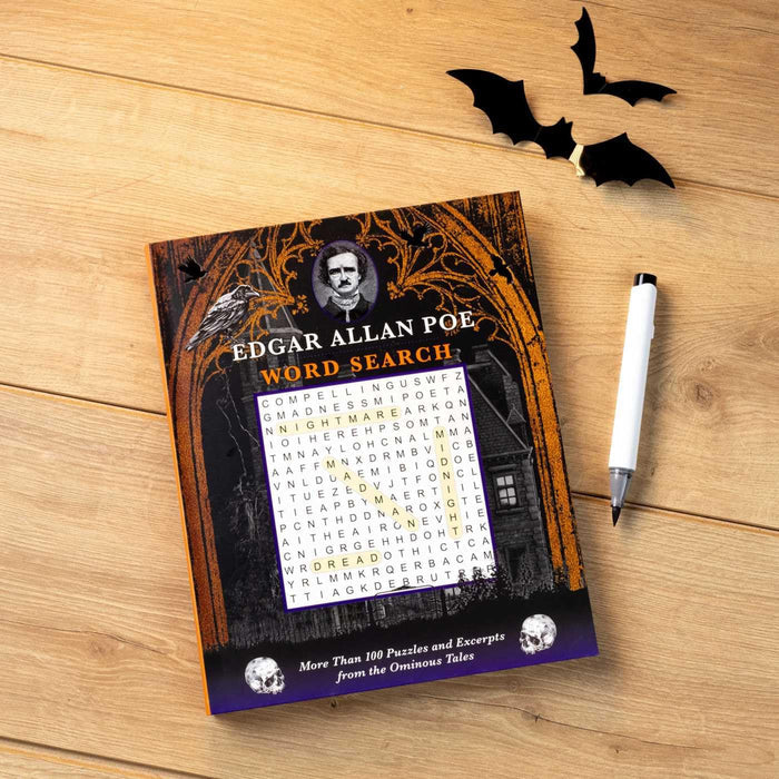 Edgar Allan Poe word search book on a wooden surface with decorative bats and a pen.