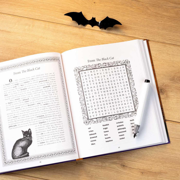 Open book with a word search puzzle and black cat illustration on a wooden surface, with a small black bat decoration above.