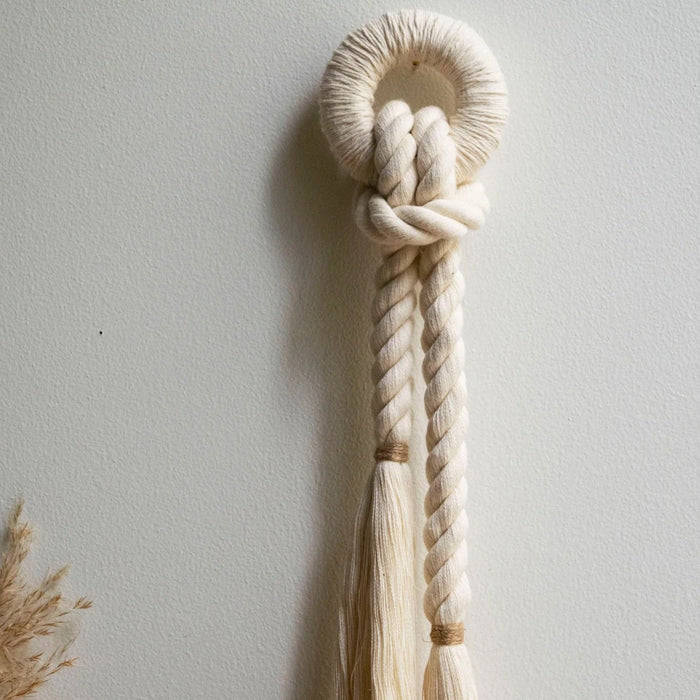Handcrafted wall decor featuring natural cotton fiber rope with a color accent of jute.