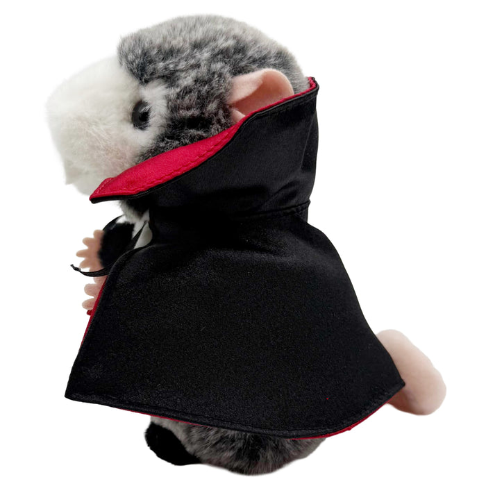 Plush toy possum in a vampire costume with red cape and black outfit on a white background