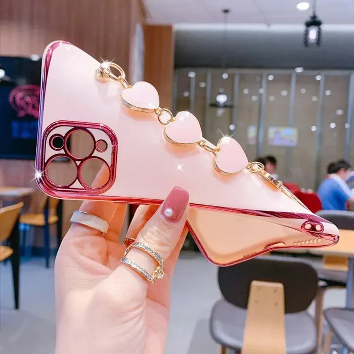a hand holding a pink phone case with a heart shaped phone