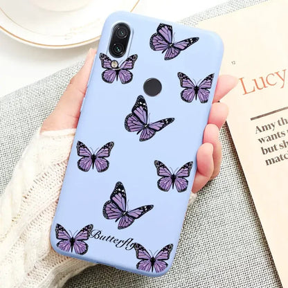 a woman holding a phone case with butterflies on it