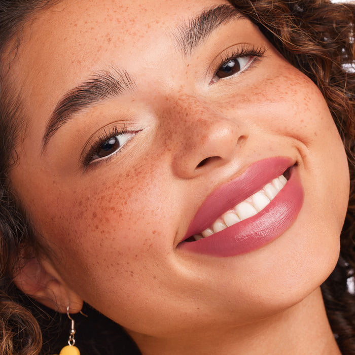 ColourPop Flurries Ultra Matte Lip coating the model's lips in a dusty mauve-pink, full-coverage matte finish, showcased in a close-up smile with natural makeup and freckles for accurate shade display.