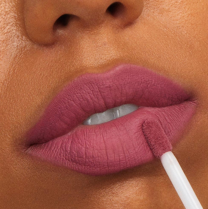 Flurries Ultra Matte Lip by ColourPop being applied with a doe-foot applicator to full lips, showing a cool mauve-rose color and smooth, shine-free finish in a tight beauty close-up for long-wear, transfer-resistant coverage.