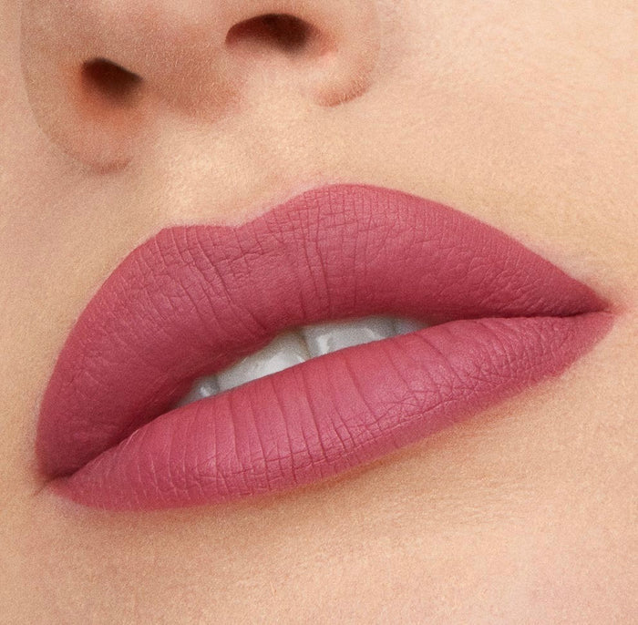Lips wearing ColourPop Flurries Ultra Matte Lip in a cool-toned dusty rose, shown in a tight close-up to showcase the smooth, opaque, transfer-resistant matte finish against natural skin.