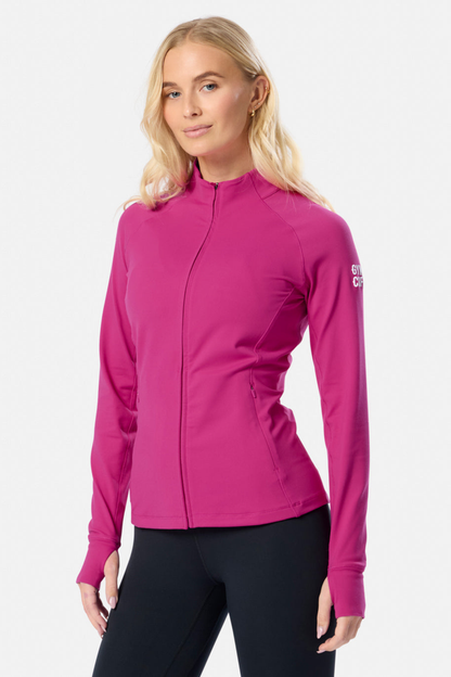 Gym+Coffee Relentless Full Zip Jacket in sunrise pink with four-way stretch and zipped pockets. A breathable, slim-fit layer for everyday wear. Shop at Dotique.