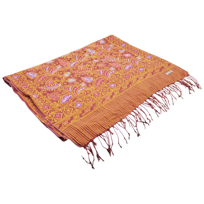 Orange and pink patterned scarf with fringes on a white background