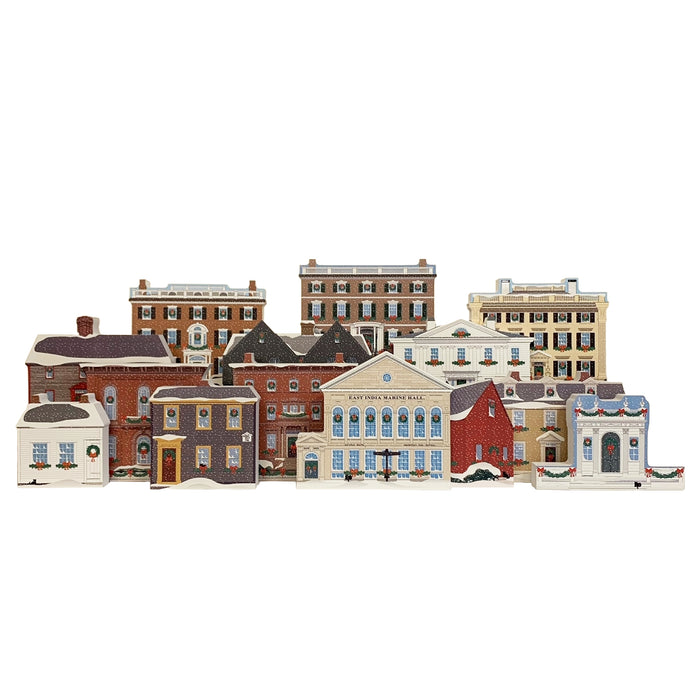 A collection of wood blocks in the shape of historic houses decorated for the holidays.