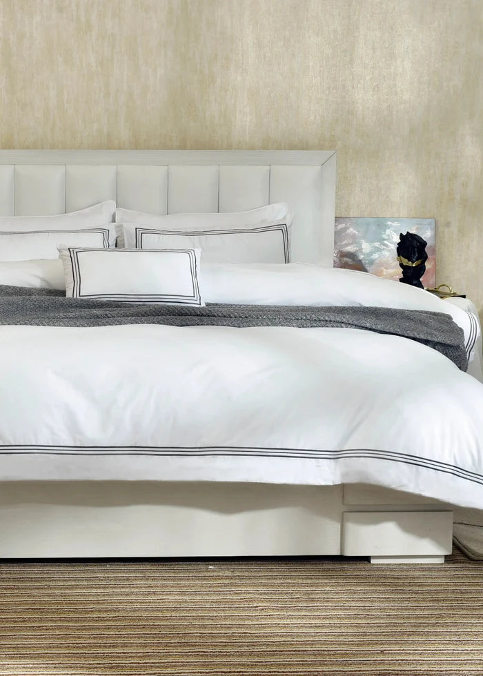 White duvet cover set with black-striped trim and matching pillow shams