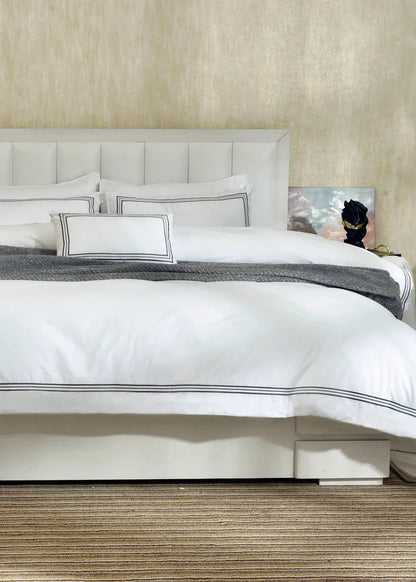 White duvet cover set with black-striped trim and matching pillow shams