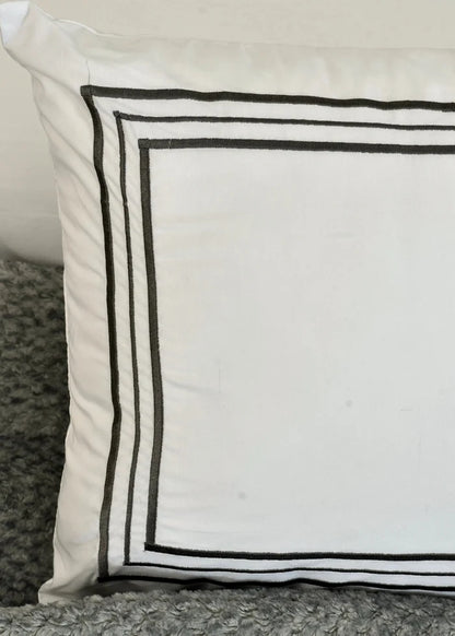 White pillow sham with double black border lines and textured gray accent