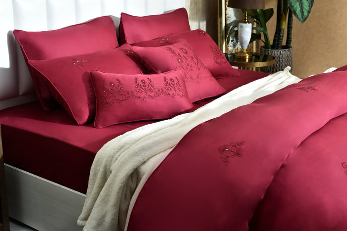 Red comforter and pillows with subtle embroidered pattern