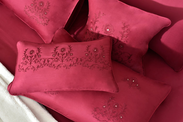 Close-up of red embroidered pillow and folded comforter