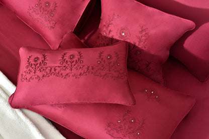 Close-up of red embroidered pillow and folded comforter