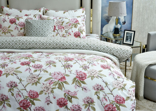 Floral cushion cover with pink rose bouquet and green patterned accent pillows