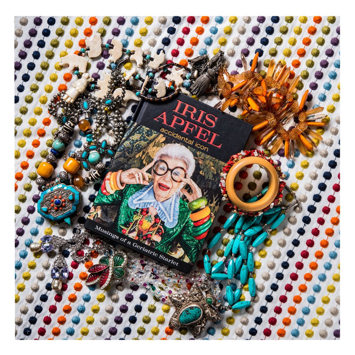 Book 'Iris Apfel: Accidental Icon. Musings of a Geriatric Starlet.' laying on a polka dot background surrounded by jewelry.
