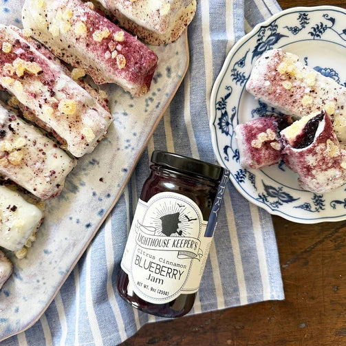 A jar of Lighthouse Citrus Cinnamon Blueberry Jam with a white label that includes the product name and a silhouette of a lighthouse.
