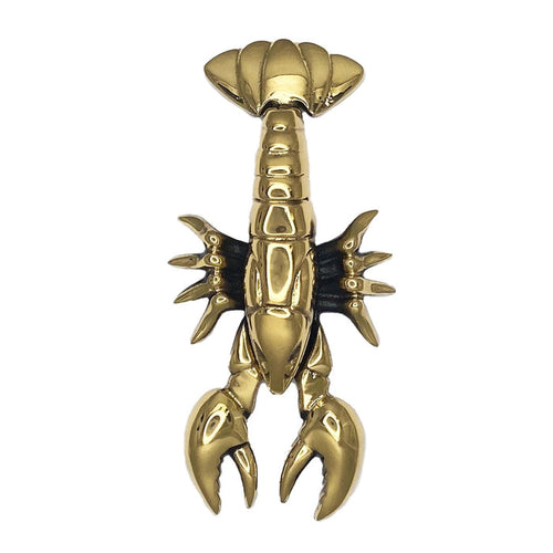 A brass door knocker in the shape of a lobster, with a highly polished finish.