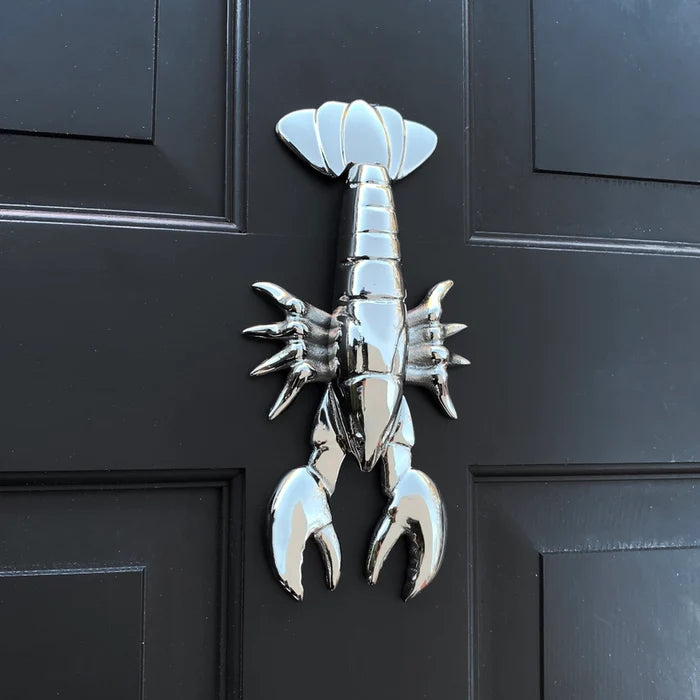 Metallic lobster door knocker on a black door