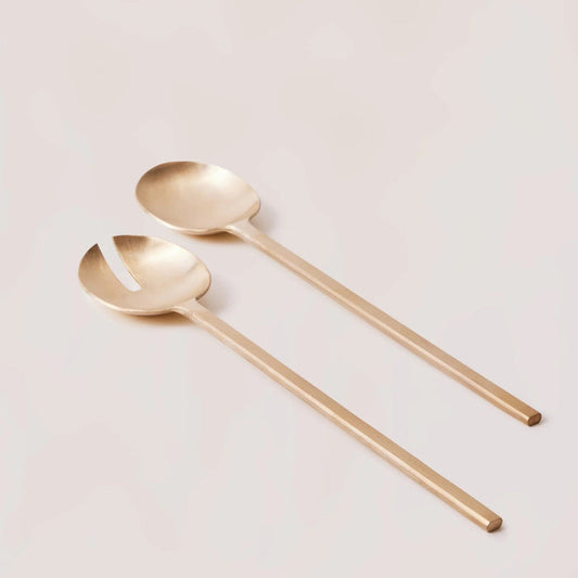 Two gold spoons on a light gray background