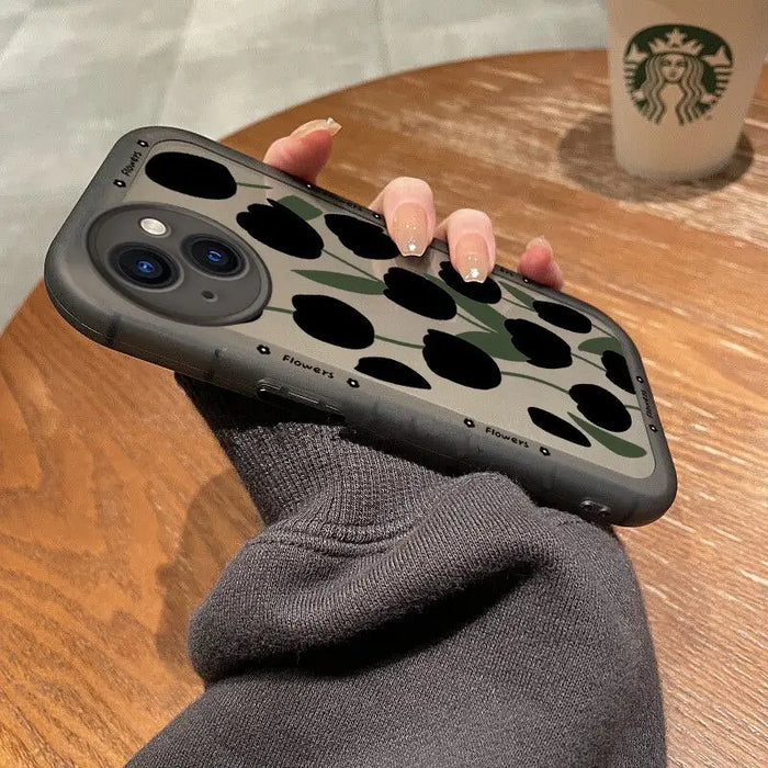 A person holding a phone case with a camouflage print