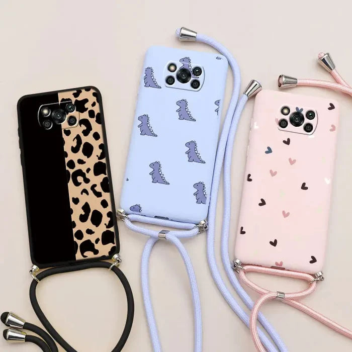 three cell phones with a strap and a phone holder on a table