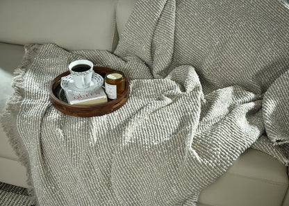 Folded brown knitted throw blanket with textured ribbed knit pattern