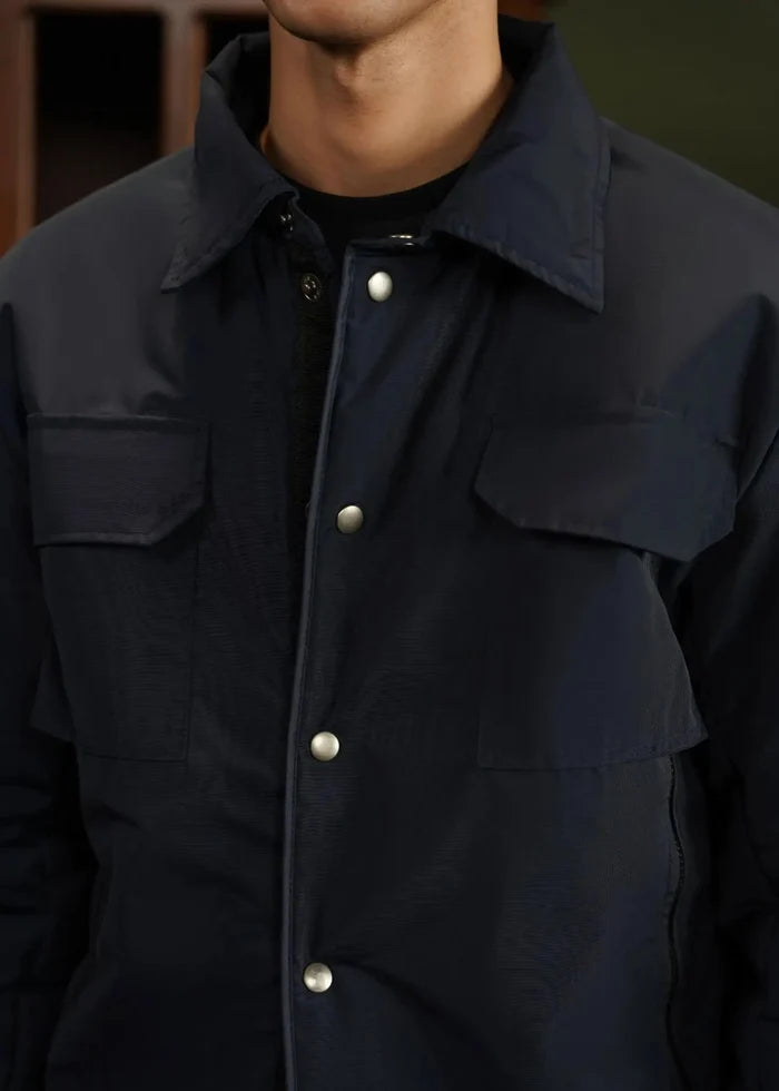 Men's navy memory jacket, chest pockets and snap-button front placket.