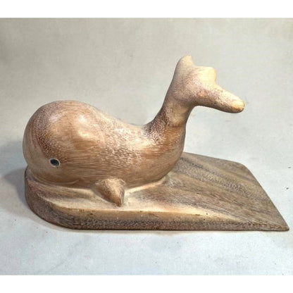 Carved wooden doorstop in the shape of a whale, with a platform under it.