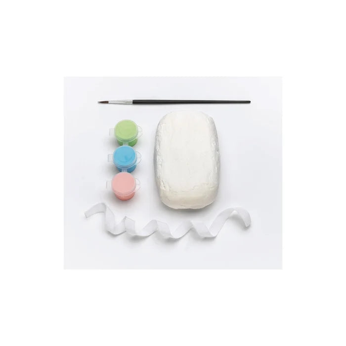 White clay with colorful paints and a brush on a white background