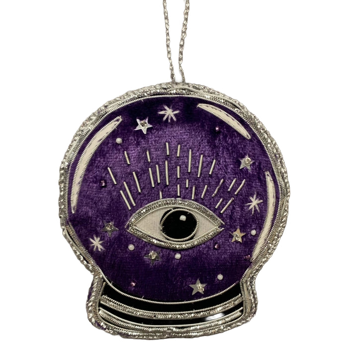 A purple velvet crystal ball ornament with silver metallic applique, featuring an eye and stars design, and the word 'Salem' on the reverse.