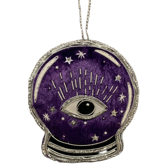 A purple velvet crystal ball ornament with silver metallic applique, featuring an eye and stars design, and the word 'Salem' on the reverse.