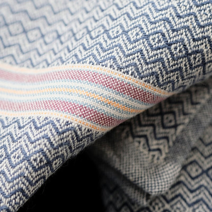 Close-up of patterned fabric with geometric design and multicolored stripe