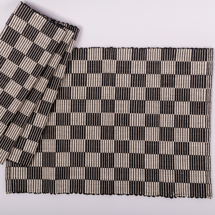 Checkerboard patterned placemat in black and cream on a white background.