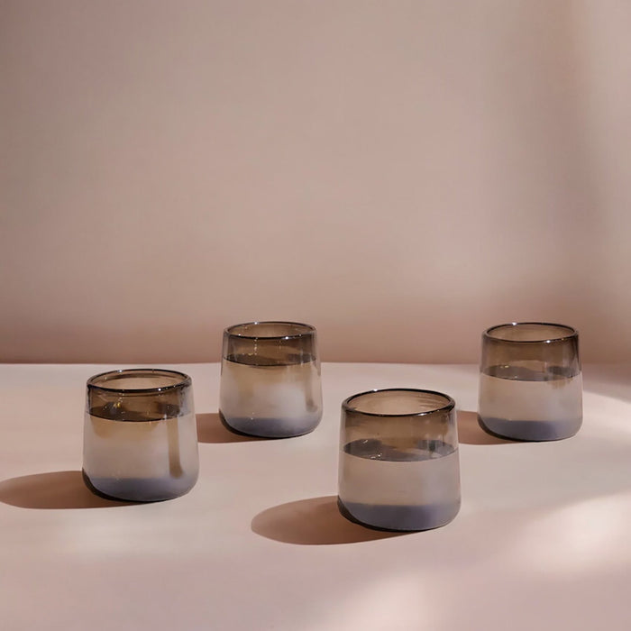 A set of four clear glasses with a smoke-like pattern on the surface, displayed on a light background.